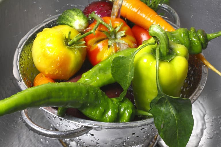 colorful vegetables in colander under water